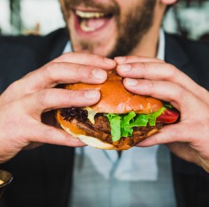 Homem comendo hambúrguer
