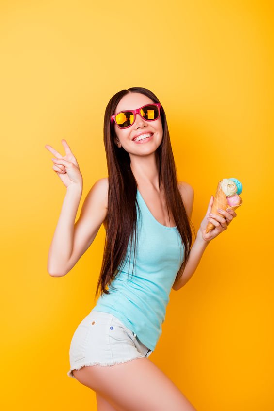 Mulher de óculos de Sol e sorvete na mão