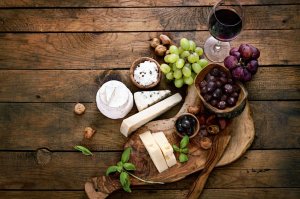 Conjunto de frutas como uvas, castanhas, ervas e queijo.