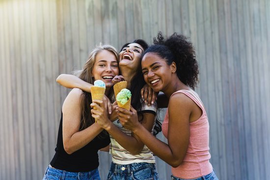 Três mulheres conversando tomando sorvete