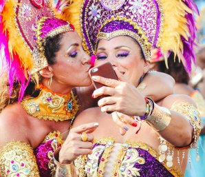 Duas mulheres tirando selfie com roupas de carnaval