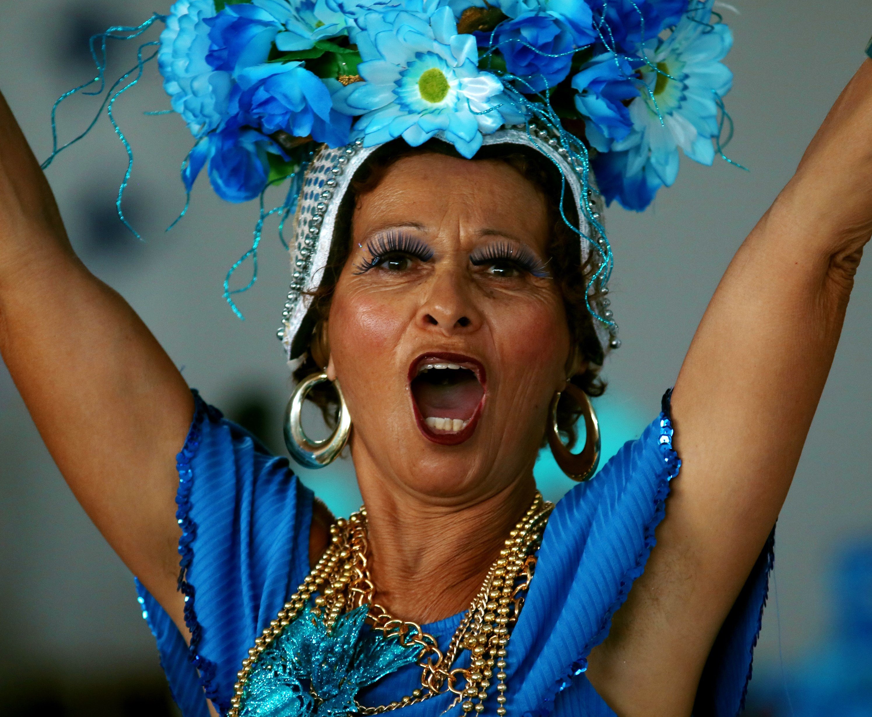 Mulher gritando com os braços para cima com roupas de carnaval