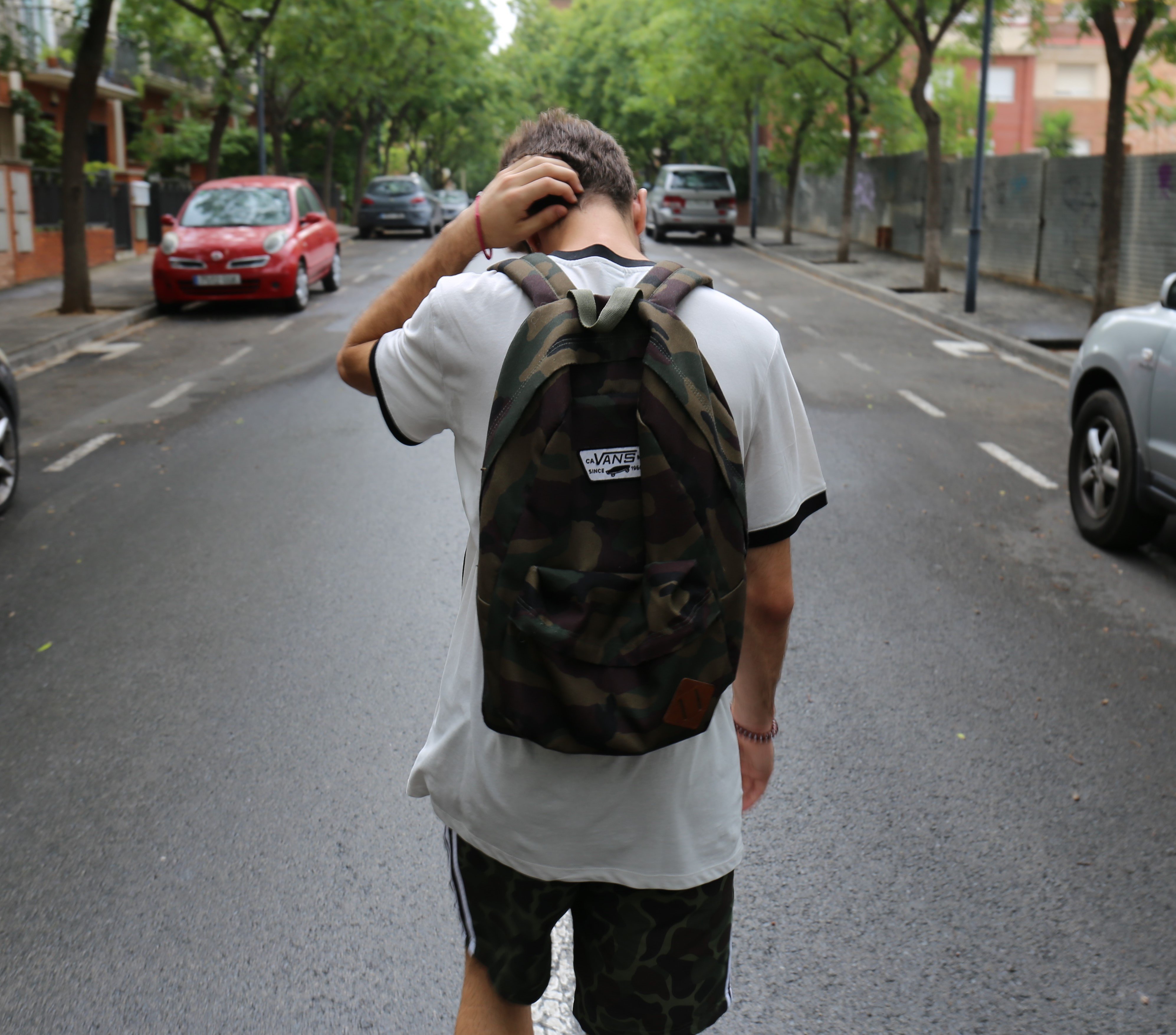 Homem andando na rua com mochila nas costas