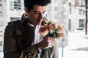 Homem segurando buquê de flores