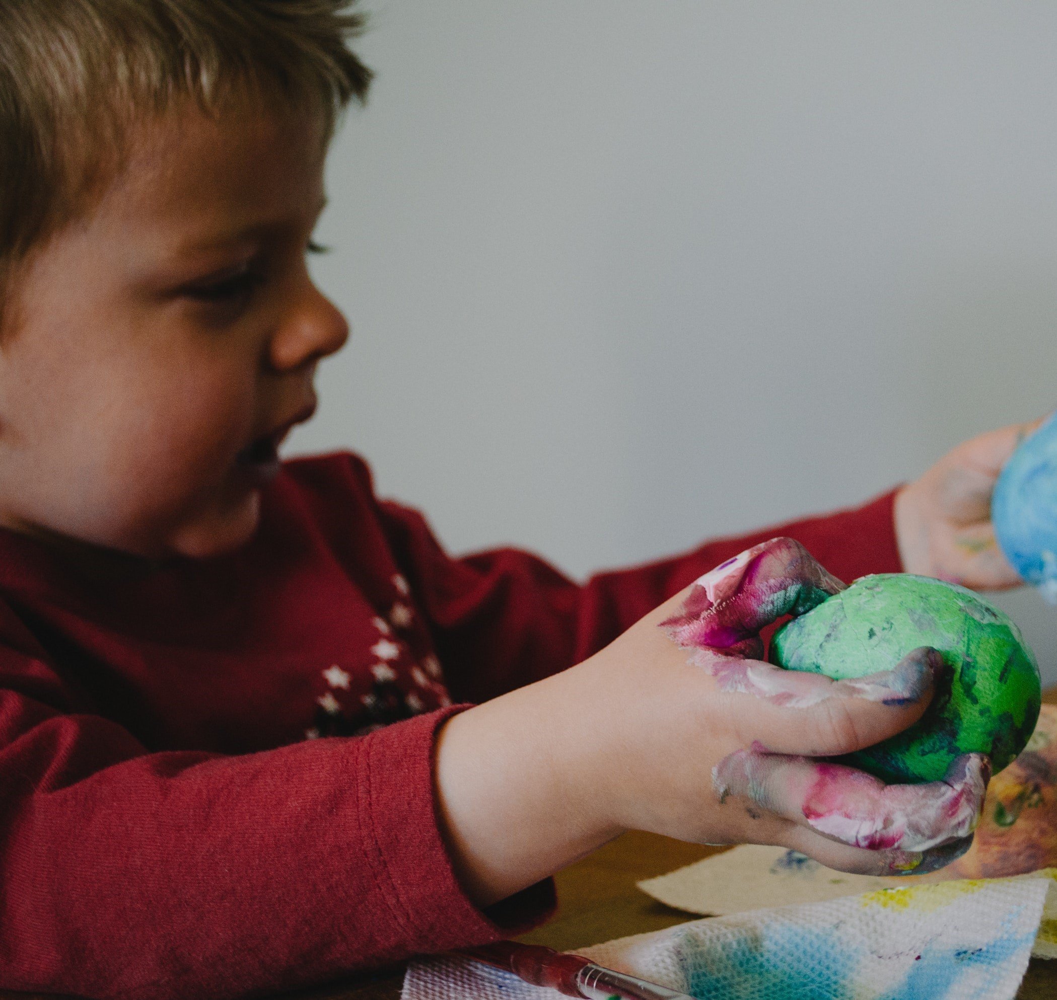 Criança brincando com ovos pintados de páscoa