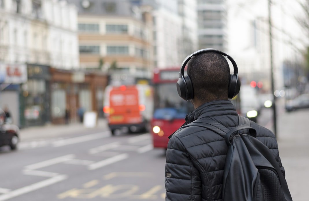 Homem andando na rua com headphones