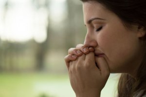 123rf Mulher com mãos unidas chorando