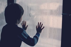 123rf Menino com as mãos em vidro embaçado