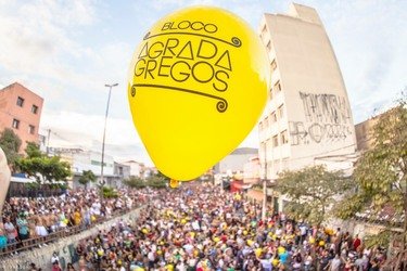 Balão escrito 'Agrada gregos' voando sobre o bloco de carnaval