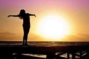 Imagem de Jill Wellington por Pixabay Mulher de braços abertos e Sol ao fundo