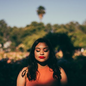 Unsplash - por Nathan Guzman Mulher de olhos fechados em paisagem natural.
