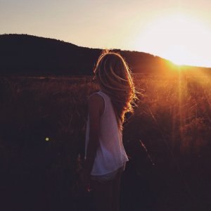 Jessica Reshot Mulher em um campo olhando para o sol