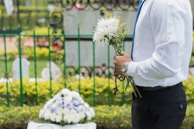 Homem com flores em cemitério