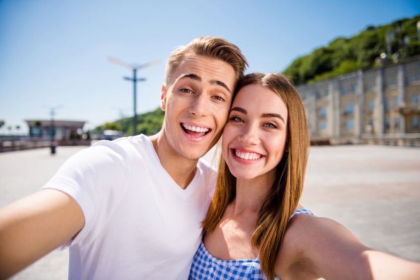 irmão e irmã sorrindo juntos para a selfie.