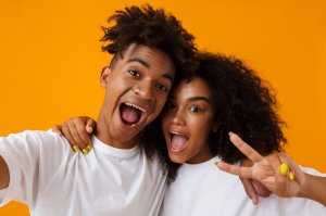 123rf. Dois irmãos, um homem e uma mulher, tirando selfie.