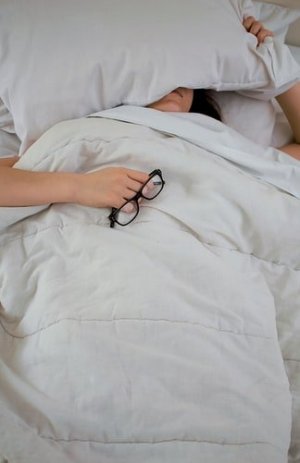 Unsplash Mulher deitada com travesseiro no rosto
