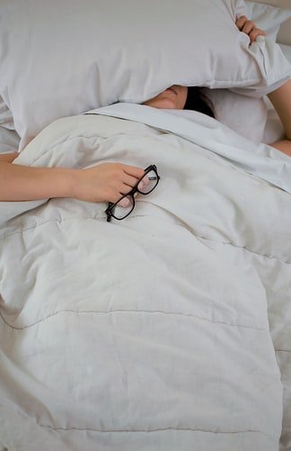 Mulher deitada com travesseiro no rosto