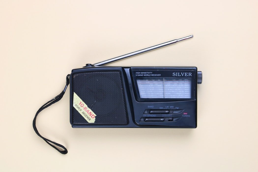 Rádio portátil preto, com antena levemente levantada.