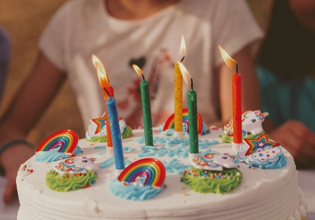 Bolo de aniversário com tema de unicórnio e arco-íris.