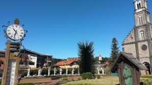 Wikipedia - Josue Marinho Praça com relógio, termômetro e igreja na Vila Suíça, em Gramado.