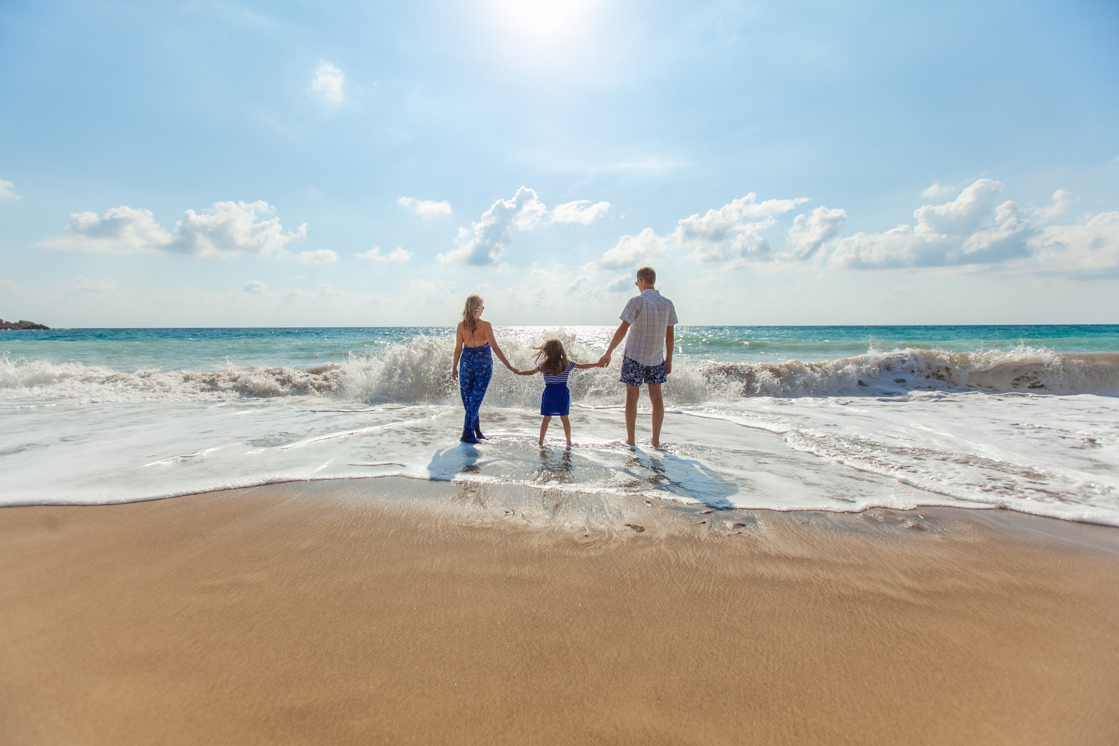 Pai, mãe e filha na praia
