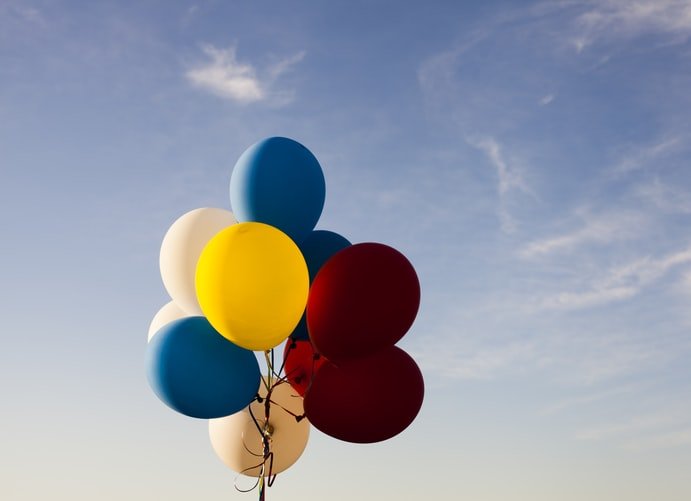 Balões coloridos com céu ao fundo