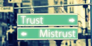 Pixabay/Gerd Altmann Placa com setas indicando direções opostas com as palavras 'Trust' (confiança) e 'Mistrust' (desconfiança)