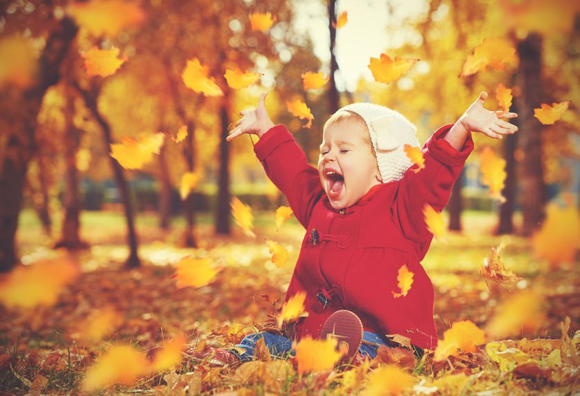 Criança feliz brincando com folhas