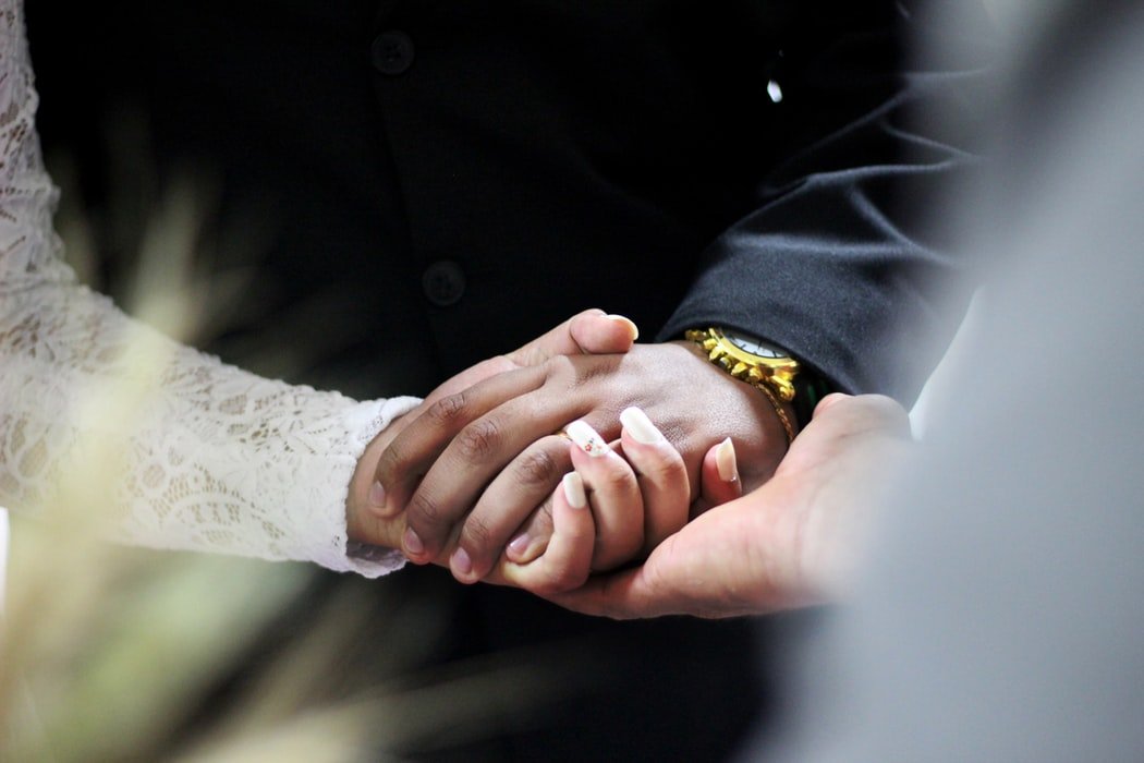 Marido e mulher de mãos dadas no casamento.