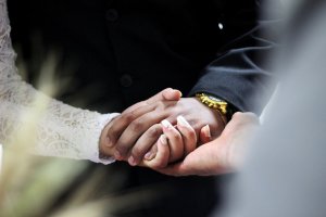 Foto por Caroline Veronez no Unsplash Marido e mulher de mãos dadas no casamento.