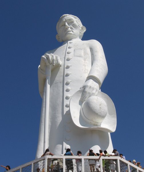 Estátua do Padre Cícero, com visitantes em sua base.