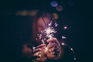 Nine Kopfer/Unsplash Mulher segurando vela brilhante.