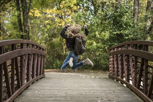 Mulher pulando de alegria em ponte
