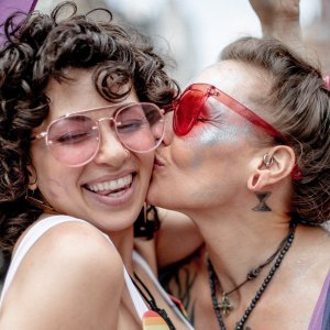 Brian Kyed Unsplash Mulher beijando bochecha de outra mulher