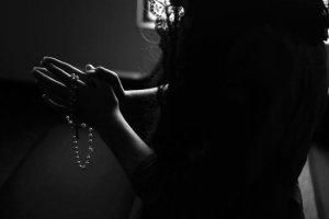 Unsplash/twinsfisch Mulher segurando terço