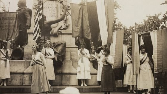 Mulheres segurando cartazes e bandeiras