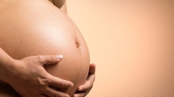 Mulher grávida seguando a barriga