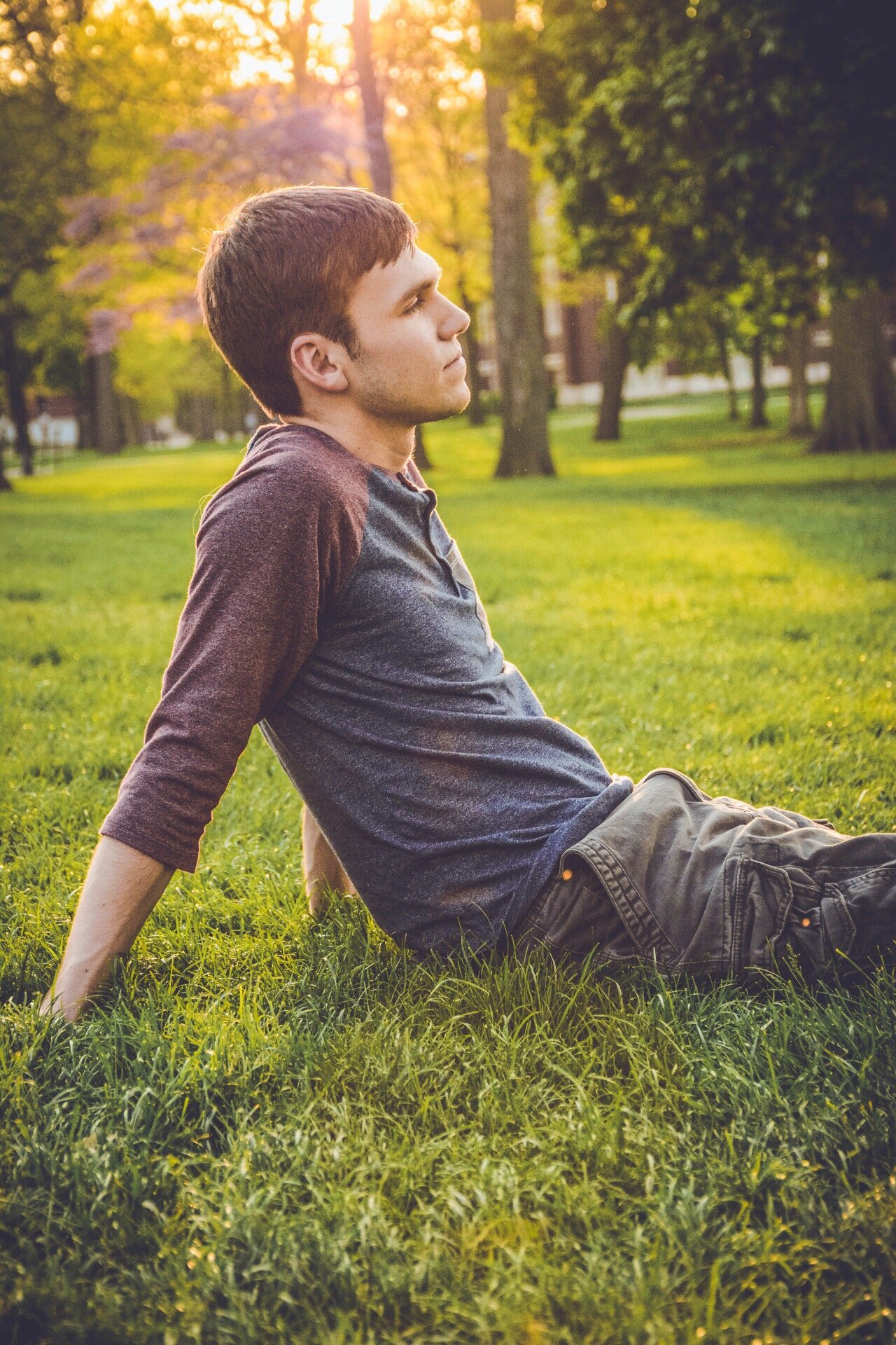 Homem sentado no gramado olhando para frente
