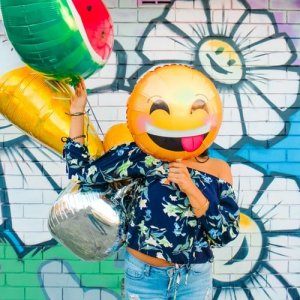 Unsplash/Lidya Nada Mulher com balão de emoticon em frente ao rosto