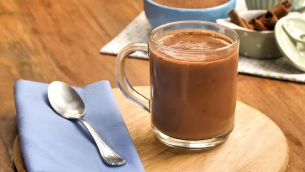 Tudo Gostoso Caneca de chocolate quente cremoso ao lado de colher