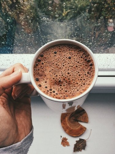 Unsplash/Nica Cn Pessoa segurando chocolate quente