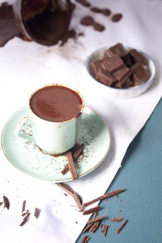 Unsplash/Hessam Hojati Chocolate quente em xícara e chocolates ao lado