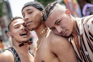 Brian Kyed/Unsplash Três homens em festa de rua.