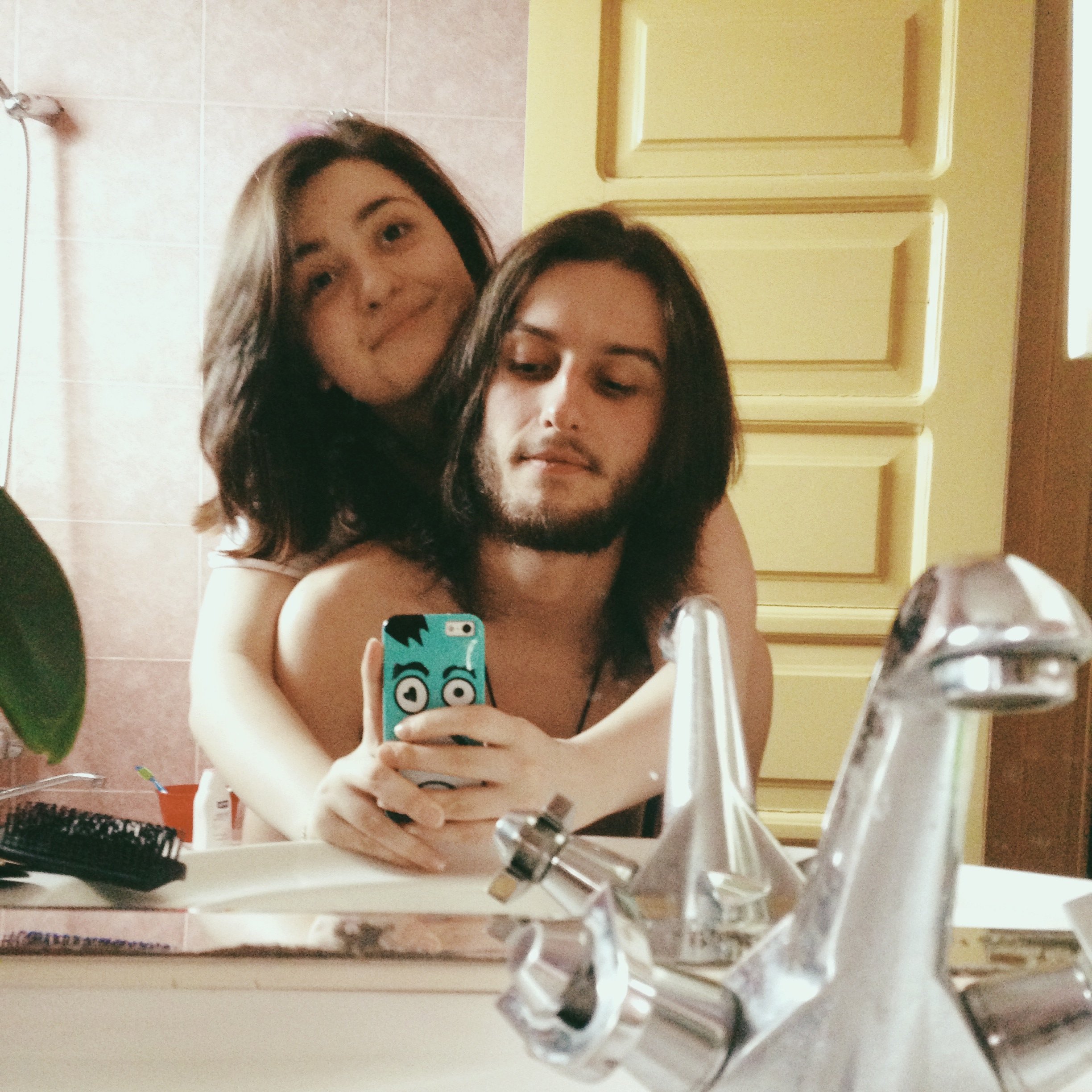 Casal tirando foto no espelho do banheiro
