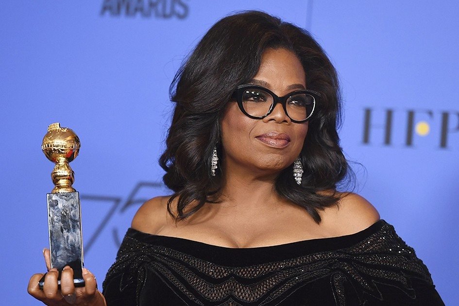 Oprah em premiação segurando troféu