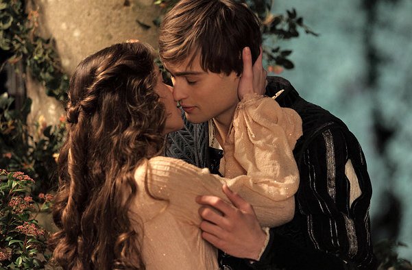 Cena do filme Romeu e Julieta se beijando ao lado de uma árvore