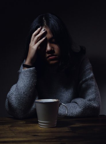 Menina preocupada tomando café