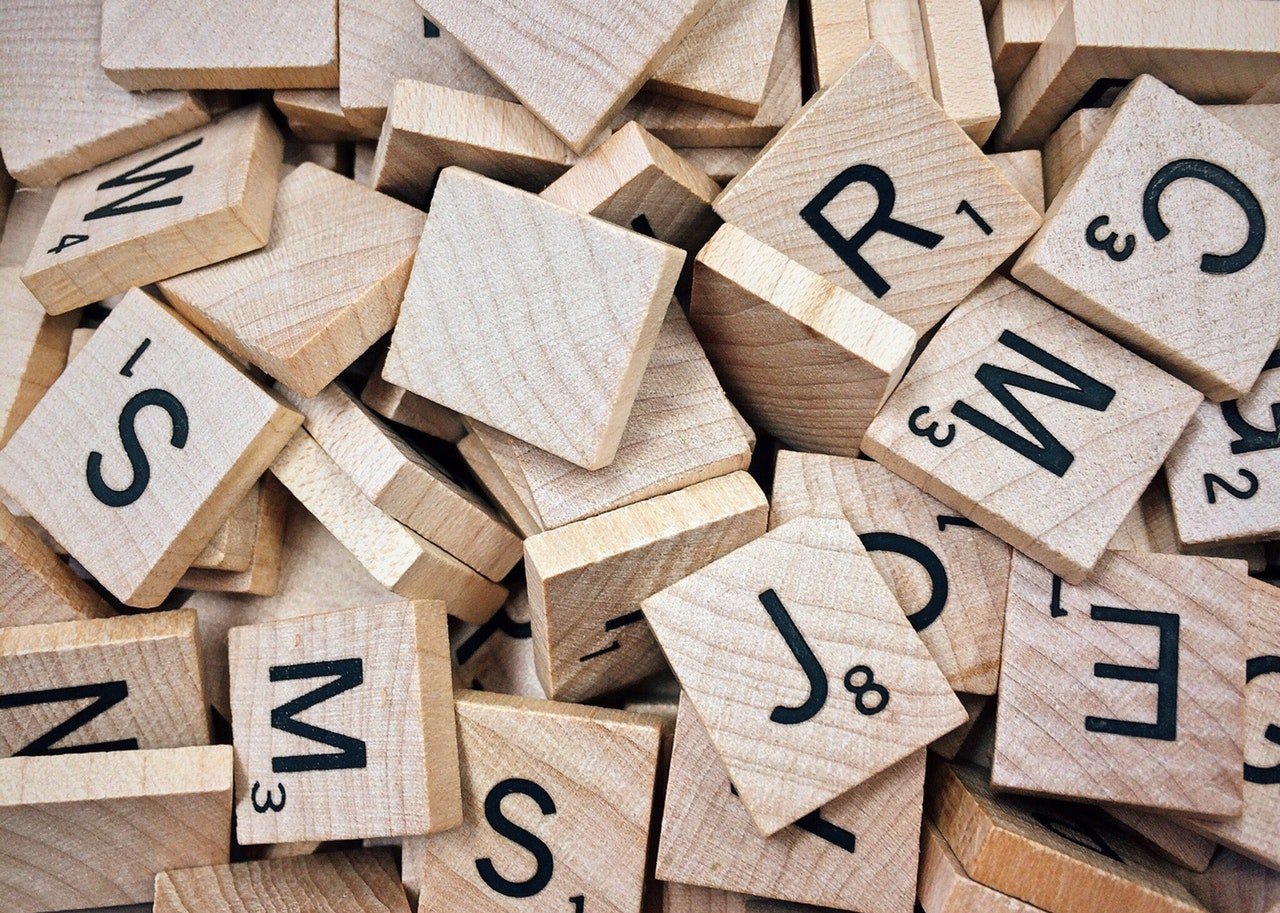 Jogo de palavras com letras escritas em pedaços de madeira.