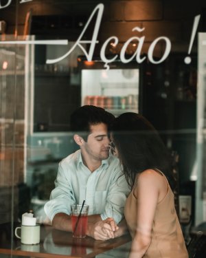 Foto de Wesner Rodrigues no Pexels Casal de mãos dadas em uma cafeteria.