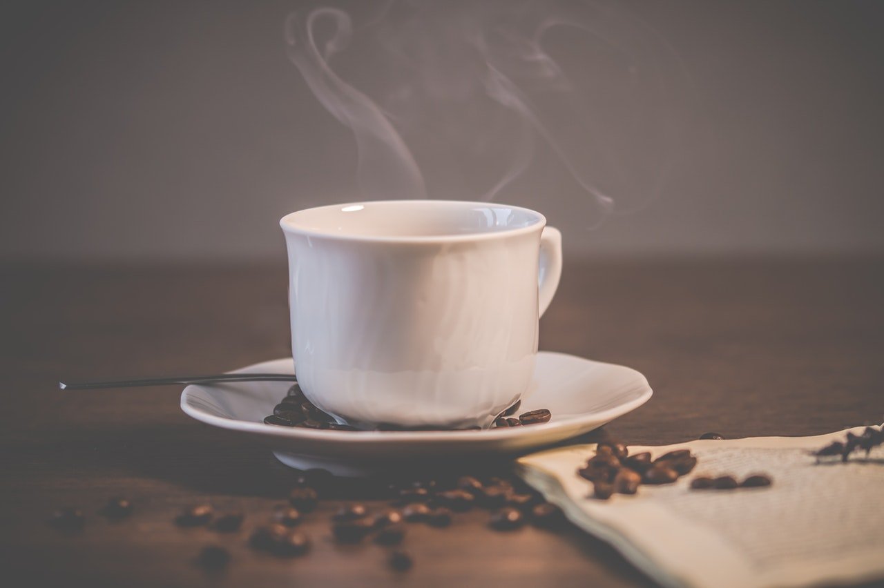 Xícara de café quente sobre uma mesa.